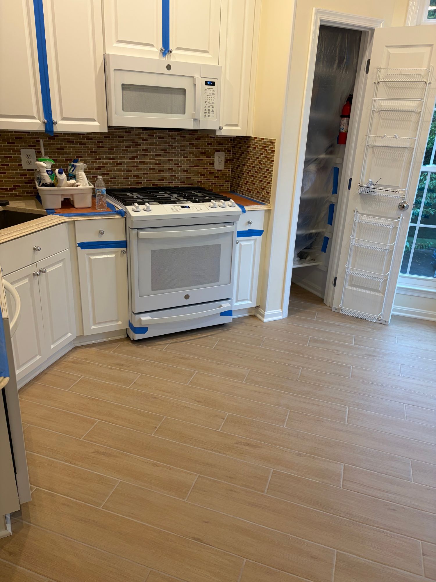 Kitchen after — new wood-look tile flooring installed, clean and finished
