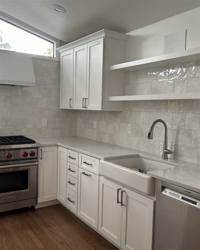 White kitchen remodel with farmhouse sink and professional range
