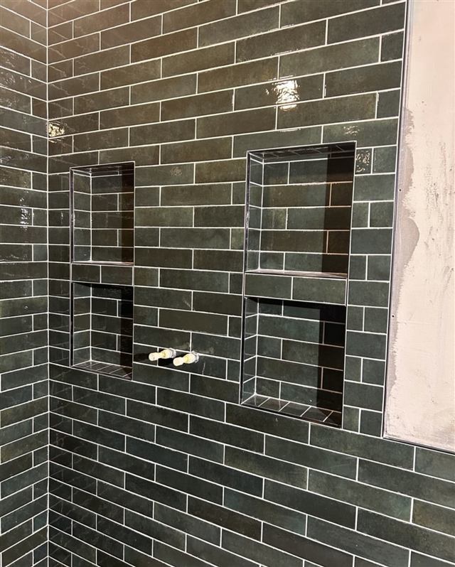 Green subway tile shower with built-in niches installed by Mavr Construction