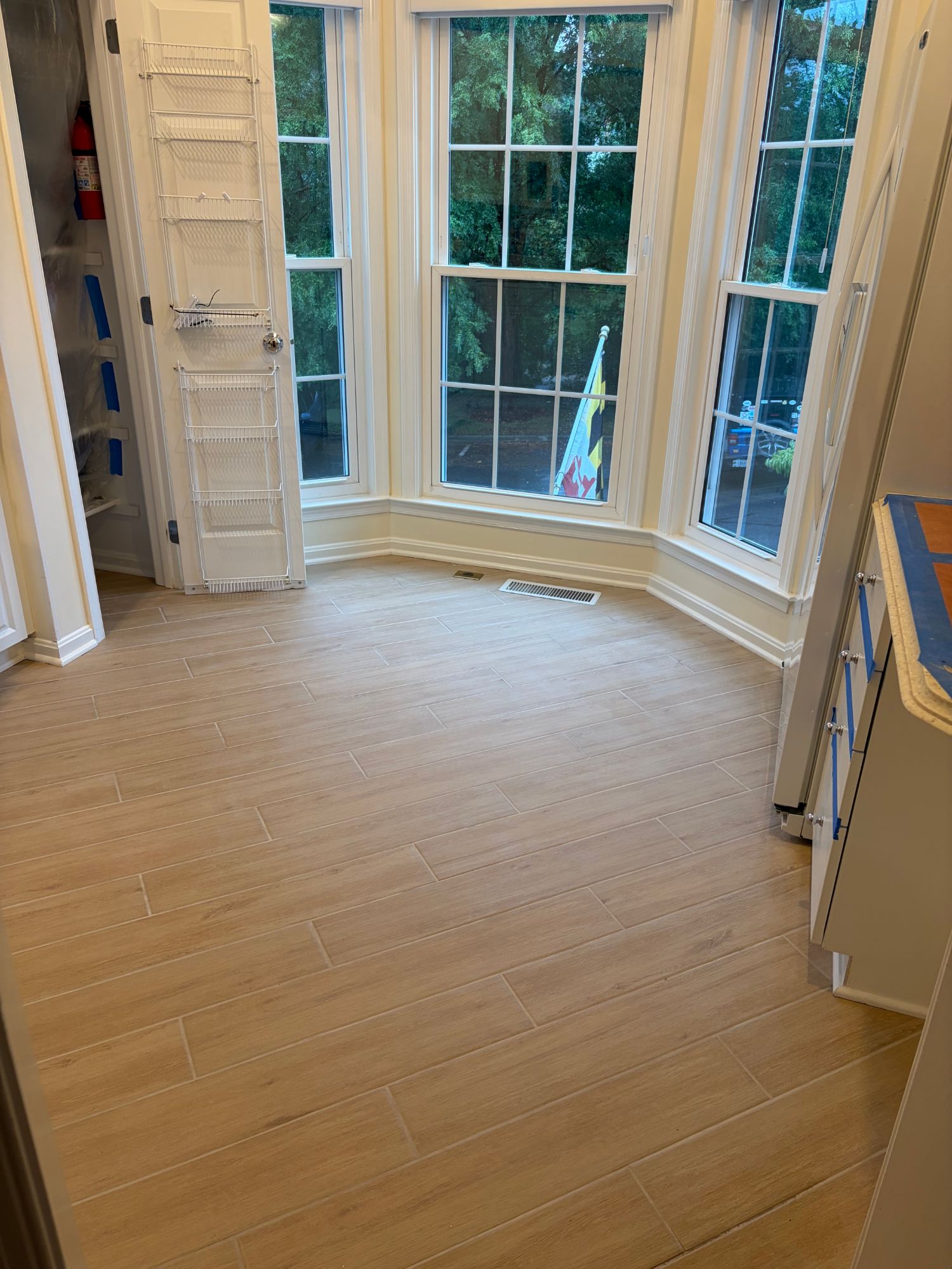 Bay window area after — new wood-look tile flooring installed throughout